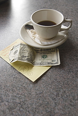 Sill life of cup of coffee money and check