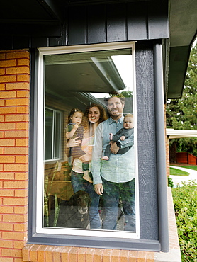 Family with children (6-11 months, 2-3) looking through window