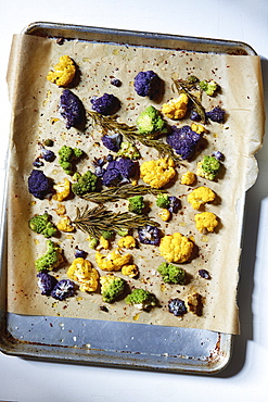 Roasted cauliflower with rosemary and olive oil on parchment paper