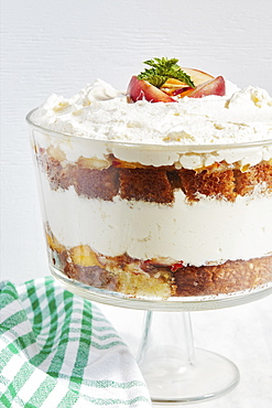 Trifle dessert with whipped cream and peaches