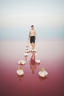 Ukraine, Crimea, Man standing on salt crystal in salt lake