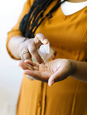 Close-up of woman cleaning hands with hand sanitizer