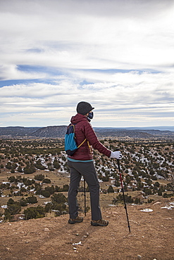 United States, New Mexico, Lamy, Galisteo Basin Preserve, Senior woman wearing face mask hiking in Galisteo Basin Preserve