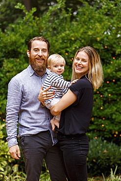 Portrait of young family, outdoors, smiling