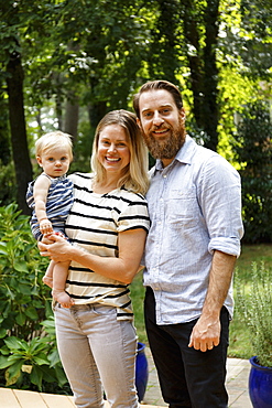 Portrait of young family, outdoors, smiling