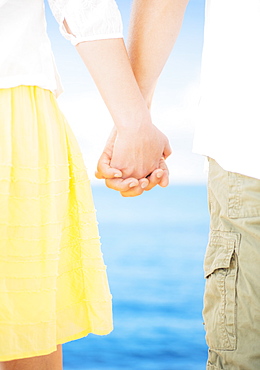 Studio Shot Mid section of couple standing and holding hands