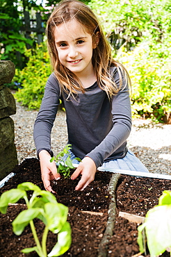 Smiling girl planting seedling