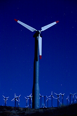 Wind turbines in landscape at night