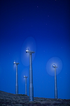 Wind turbines in landscape at night