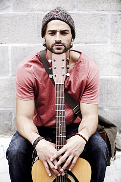 Portrait of musician against brick wall