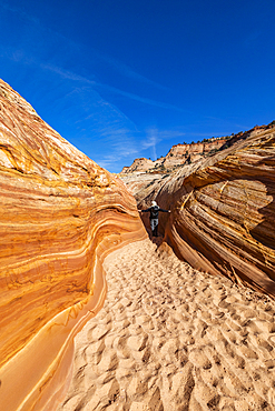 United States, Utah, Escalante, Senior hiker walking in sandstone canyon