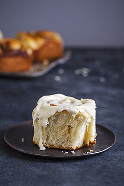 Cinnamon bun with icing on plate