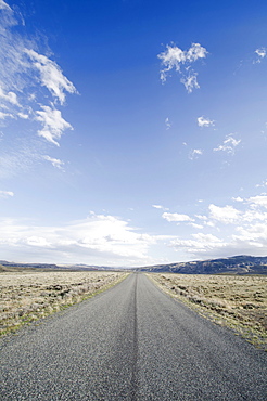Road going through desolate landscape, Wyoming, USA