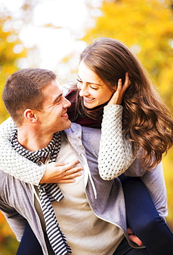 Man giving piggy back ride to woman in park, USA, New York State, New York City