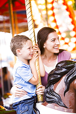 Mother and son (4-5) on carousel in amusement park, USA, Utah, Salt Lake City 