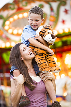 Mother giving her son (4-5) piggyback ride in amusement park, USA, Utah, Salt Lake City 