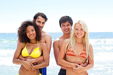 Two couples holding each other by the water