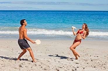 Happy couple playing with beach racket