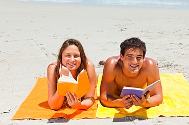 Portrait of a tanned couple reading a book