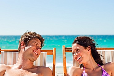 Close-up of lovers laughing while taking a sunbath