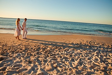 Lovers walking on the beach at the end of the day