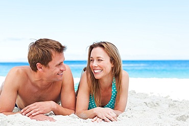 Happy couple lying on the beach together