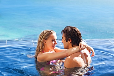 Side view of couple hugging in the pool