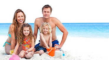 Family building sandcastle on the beach