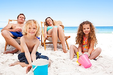 Parents watching their children playing on the beach