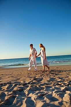 Couple walking on the beach at the time of sunset