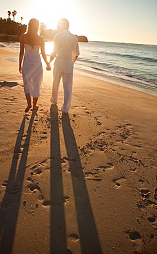 Sunset with lovers walking on the beach