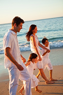 Family walking hand in hand on the beach