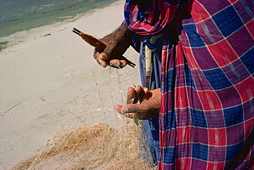 Mending fishing nets by the Indus at Kotri, Pakistan, Asia