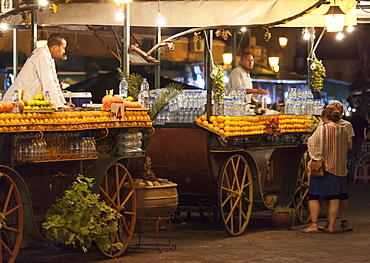 Orange juice sellers and tourists in the Djemaa El Fna at sunset, Marrakech, Morocco, North Africa, Africa 