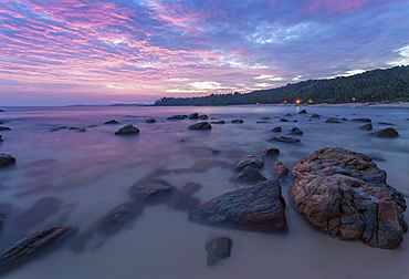 Long exposure of a pink sunset at the beach during dusk with rocks in the foreground, Tangalle, Sri Lanka, Asia 