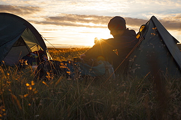 A camper sits in the evening sun, Picws Du, Black Mountain, Brecon Beacons National Park, Wales, United Kingdom, Europe