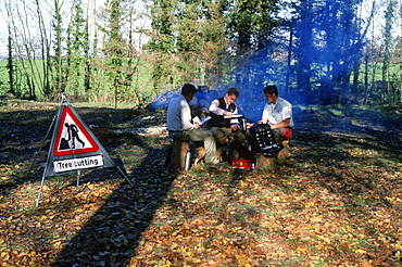 Tree surgeons resting by the fire, UK