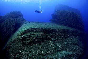 Diver in volcanic formations, El Hierro, Canary Islands