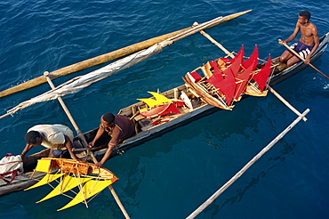 Local men transport model boats by canoe to market, Nosy Be Island, Madagascar, Africa