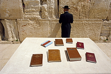 Religious books on table and Jewish man facing the Western Wall, Jerusalem, Israel, Middle East