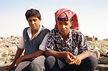 Portrait of two young local guides, one wearing traditional headcloth, at the ruins at Umm al Jimal, Jordan, Middle East