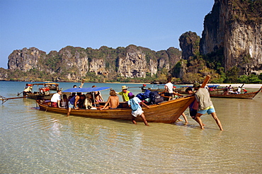 Launching a long tail boat full of backpackers from Railay Beach to Krabi in Thailand, Southeast Asia, Asia