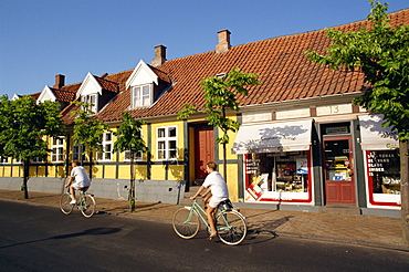 Cyclists pass small shop in Ronne, Bornholm Island, Denmark, Scandinavia, Europe