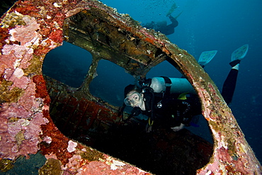 Diver entering the front window of a four seater plane wreck, Philippines, Southeast Asia, Asia