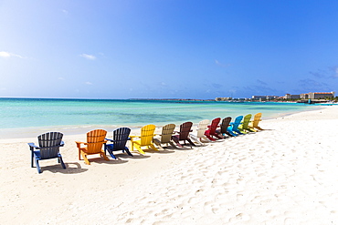 A row of colourful wooden deckchairs on Palm Beach, Aruba, Netherlands Antilles, Caribbean, Central America