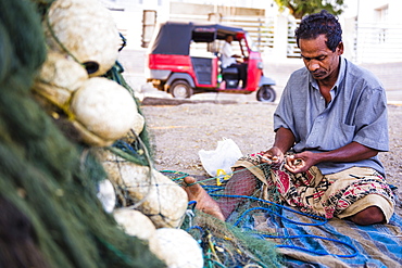 Portrait of a fisherman mending his fishing nets in Negombo, West Coast, Sri Lanka, Asia 