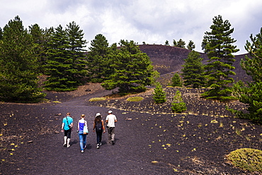 Tourists exploring an old lava flow from an eruption of Mount Etna Volcano, UNESCO World Heritage Site, Sicily, Italy, Europe