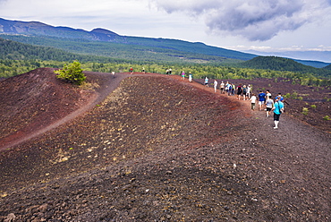 Tourists exploring an old lava flow from an eruption of Mount Etna Volcano, UNESCO World Heritage Site, Sicily, Italy, Europe