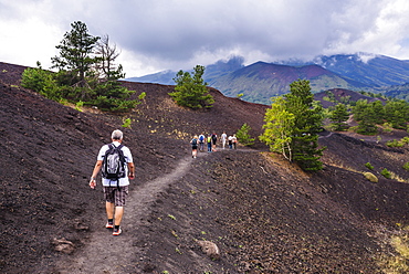 Tourists hiking on an old lava flow from an eruption, Mount Etna, UNESCO World Heritage Site, Sicily, Italy, Europe