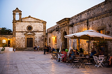 Tourist at a restaurant, Church of St Francis of Paolo in the main square, Marzamemi, Sicily, Italy, Europe 